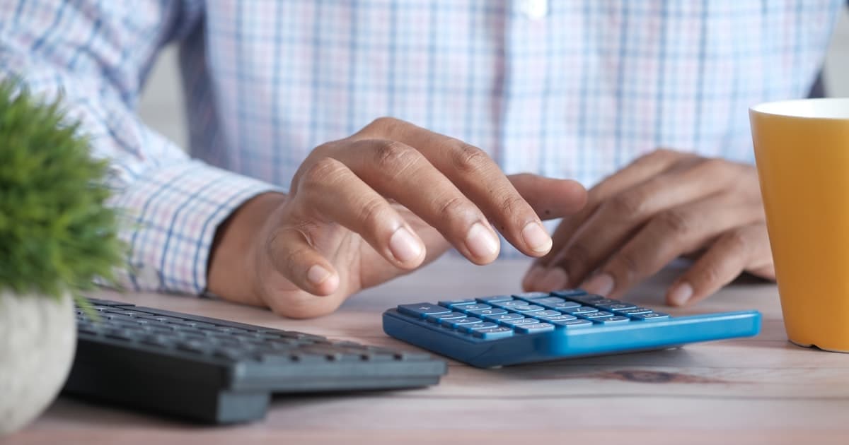 Person berechnet Minijob-Verdienst am Taschenrechner