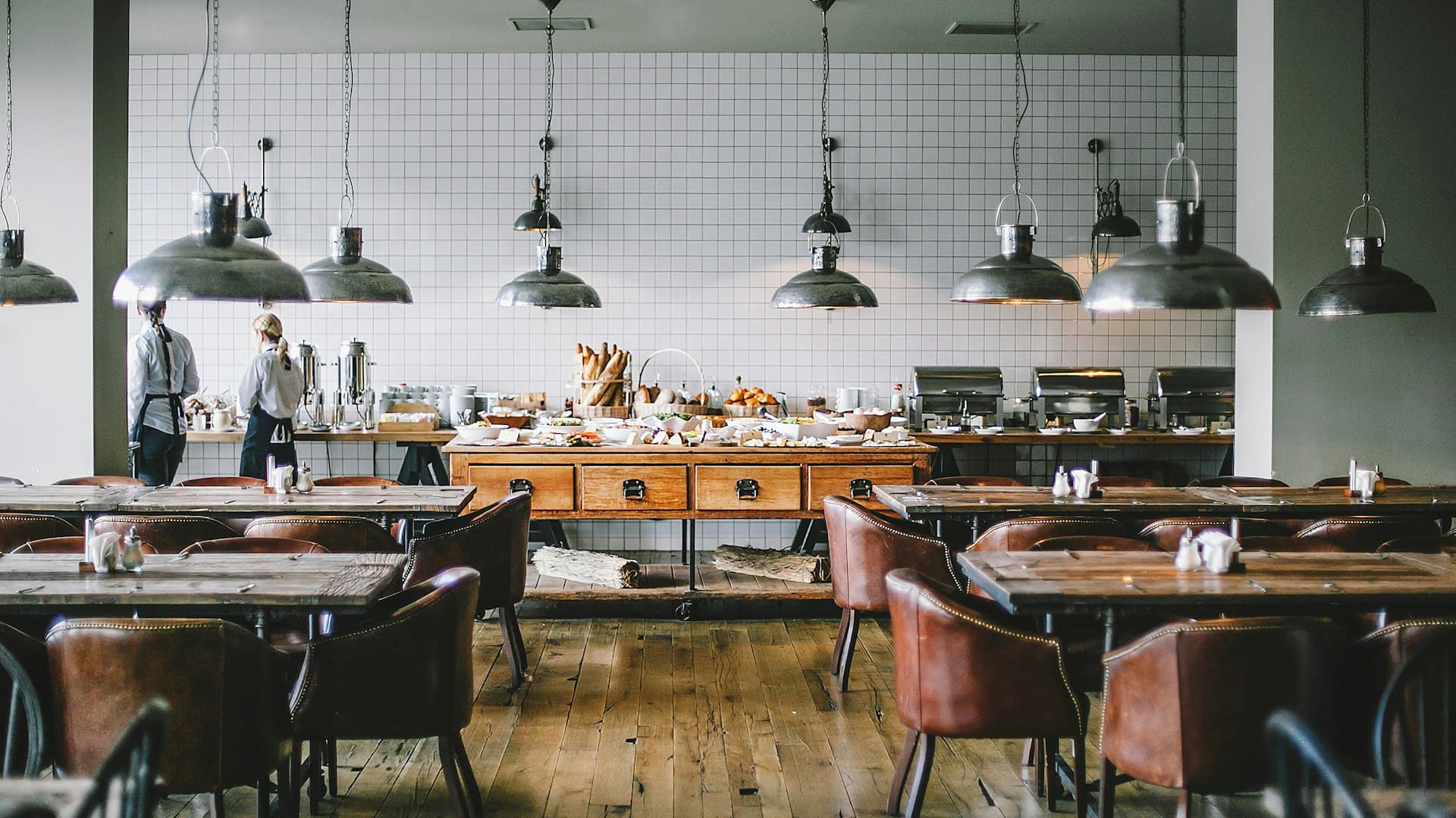 Warmes Restaurant-Interieur mit Holztischen und Industrielampen